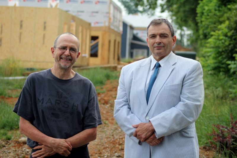 Two men standing in front of new residential construction.