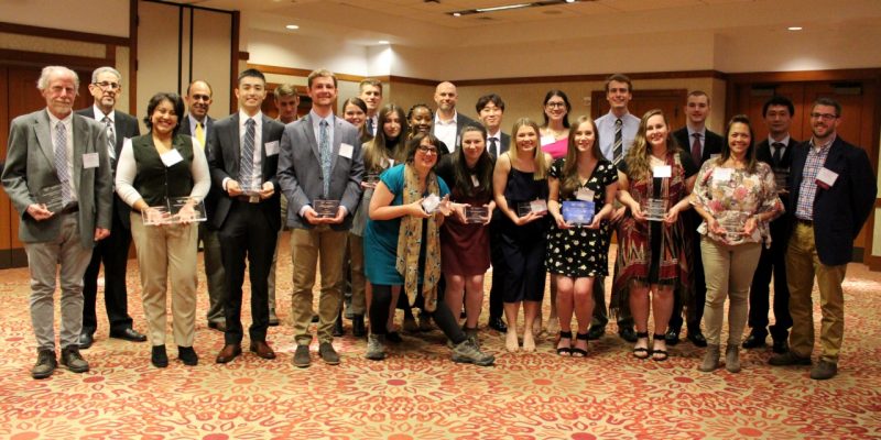 A group of award winners holding their awards