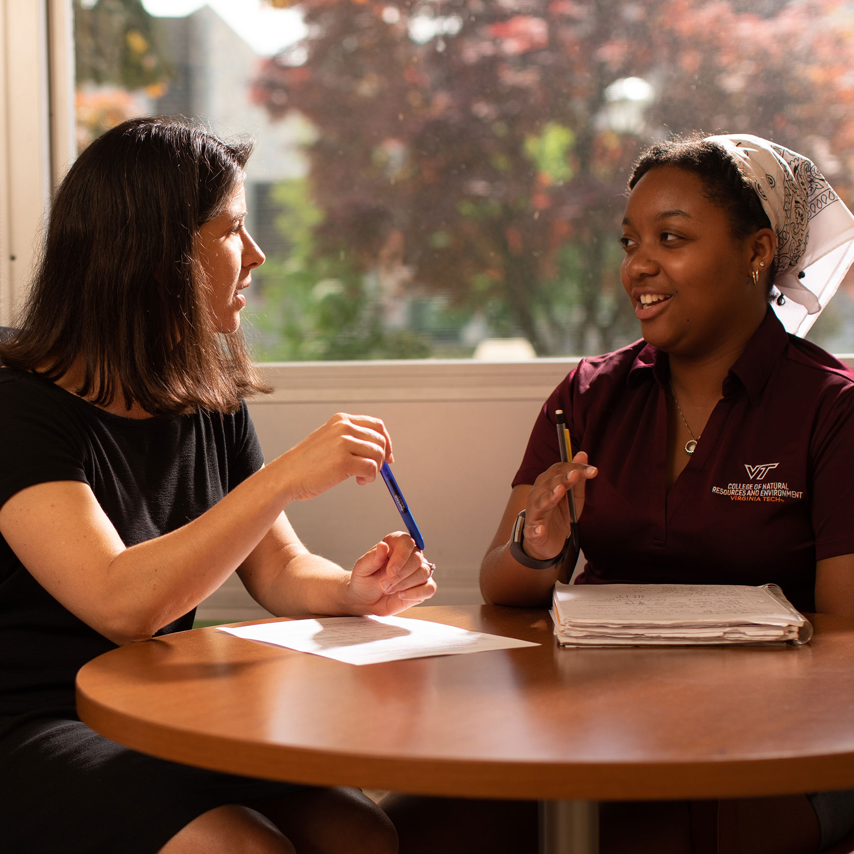 A young student talking with her advisor.