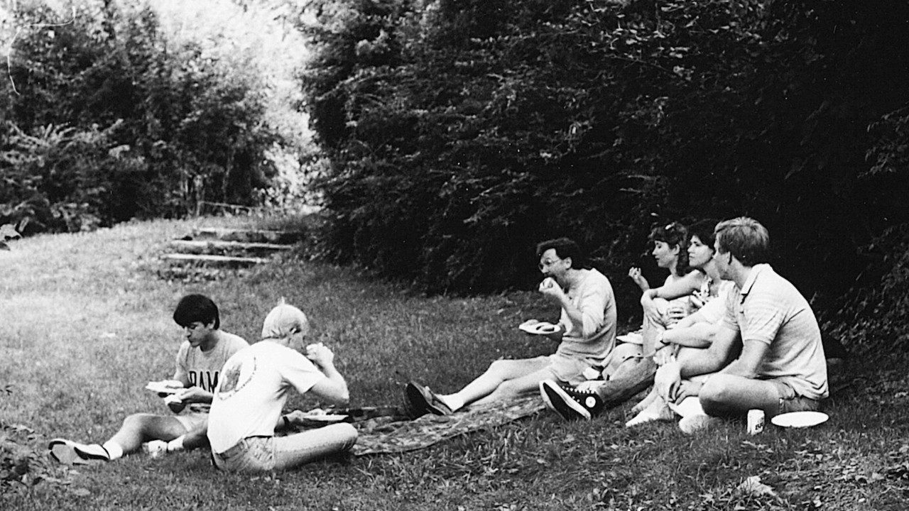 Students sitting on the ground in the shade having a picnic