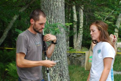 Graduate student Chris Latimer (L) explains to Kristen Booher how to properly load a pole dart for chemical immobilization.