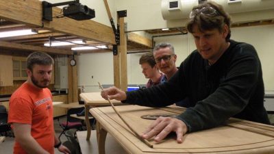 Andrew Corbin, Eoghan O’Connor, Professor Earl Kline, and Jeremy Withers meticulously apply the sycamore inlay.