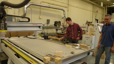 Eoghan O’Connor removes a precision-machined table leg from the CNC automated router.