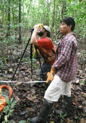 Scientist uses a dendrometer to measures trees in the rainforest.
